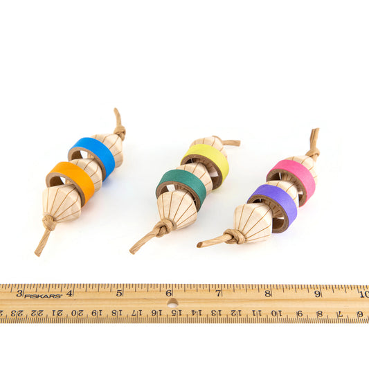 Colorful wooden bird toys with a ruler for scale. They are 4 inches long by 1 1/2 inches in diameter.