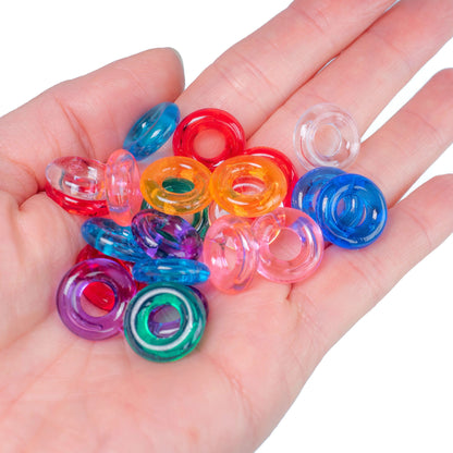 Colorful plastic rings on a hand against a white background