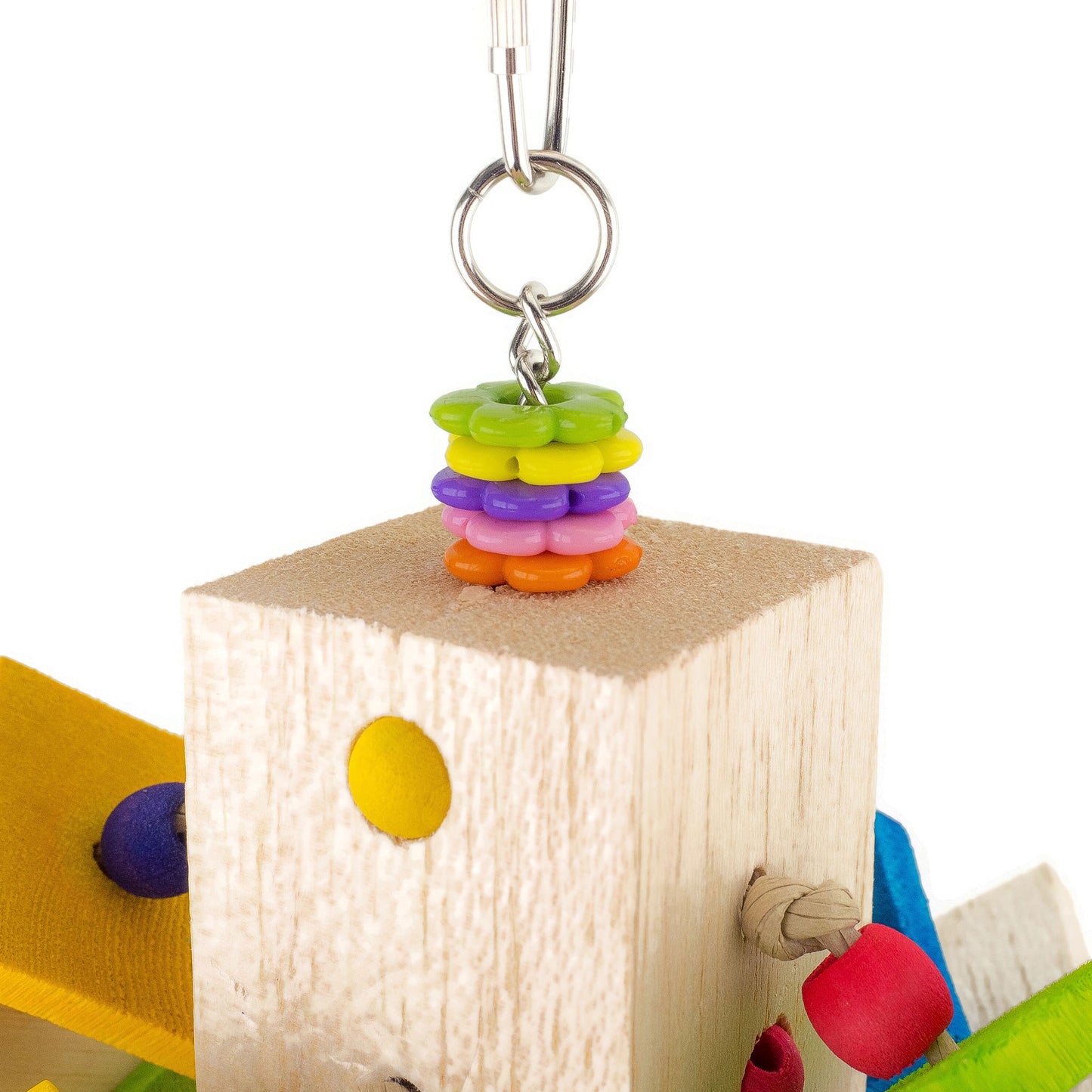 Colorful beaded charm on a wooden block with a white background