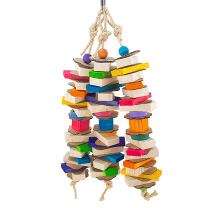 A hanging bird toy made of stacked wooden blocks and cardboard sheets in many bright colors, suspended by a sisal rope.