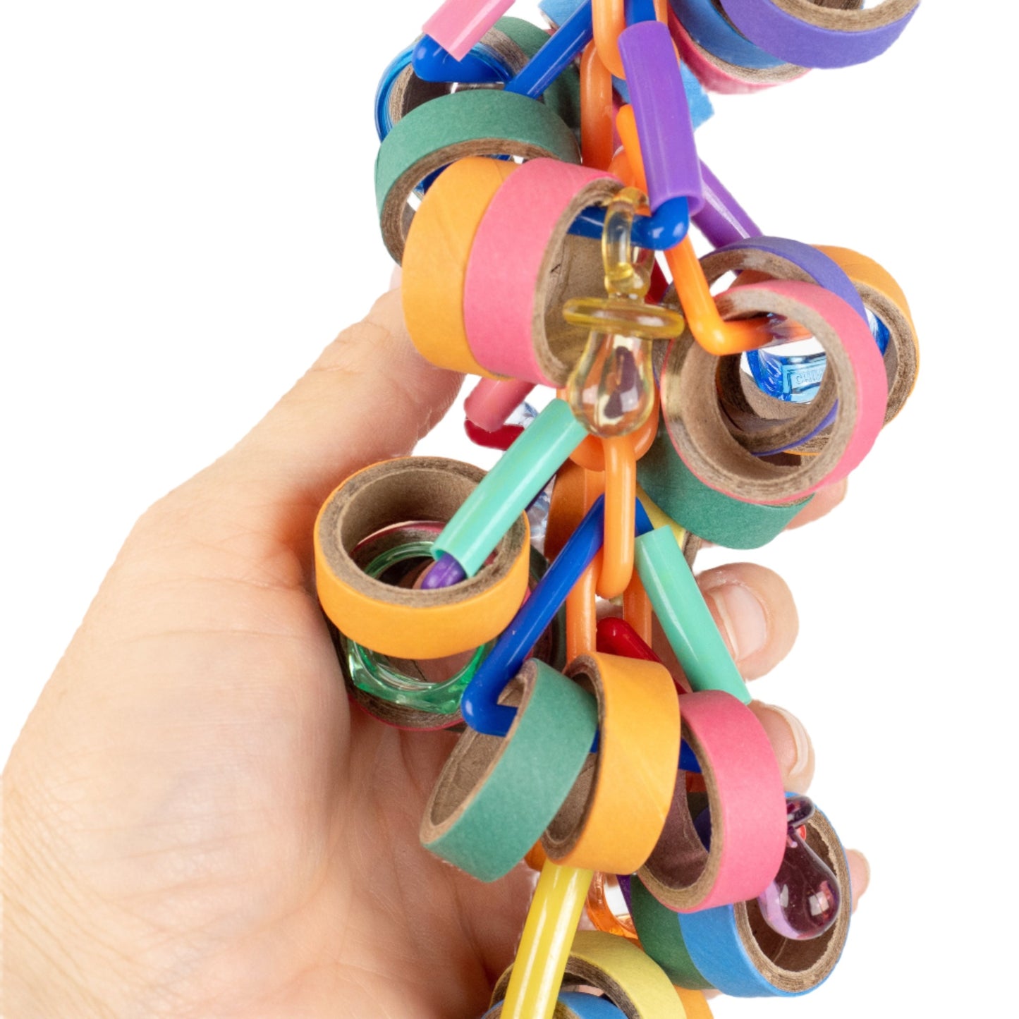 A close up of a hand holding a colorful hanging bird toy with paper rings and a chain of pacifiers for shredding.