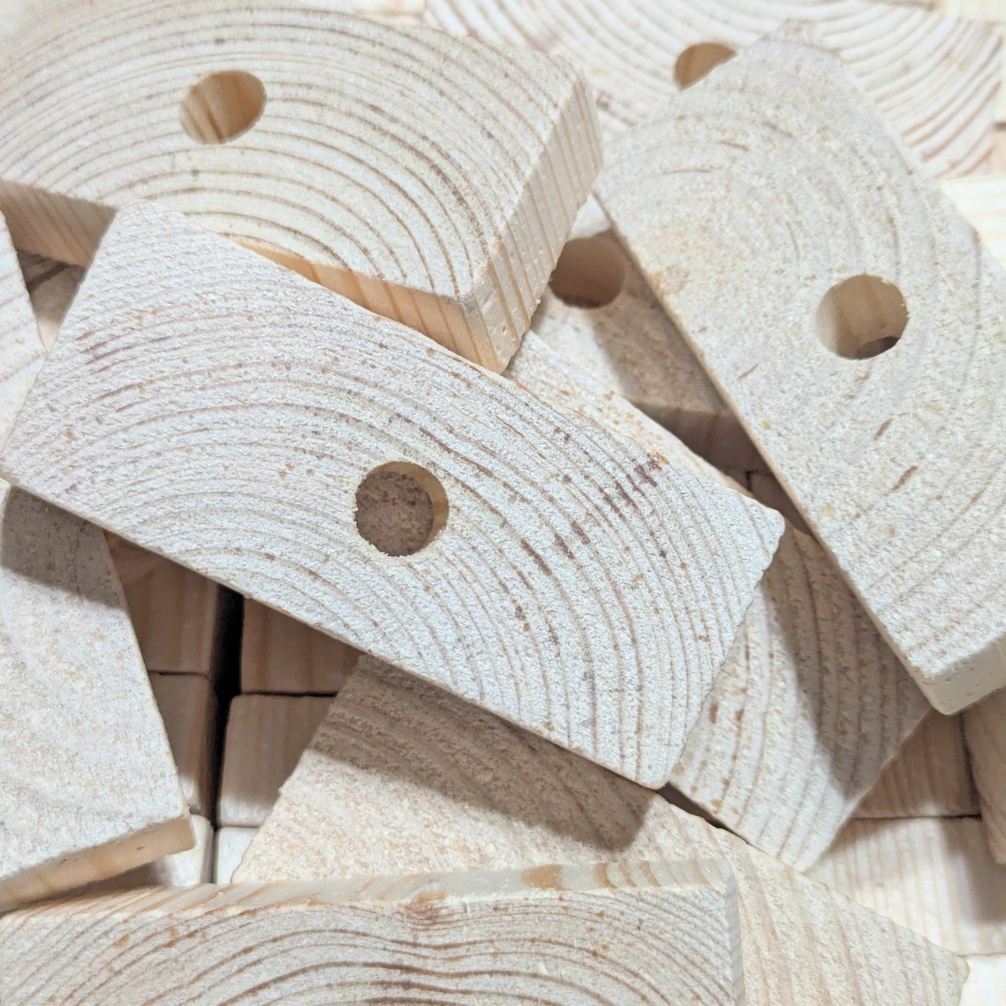 Close-up of wooden blocks with holes for making bird toys.
