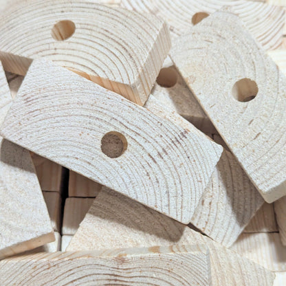 Close-up of wooden blocks with holes for making bird toys.