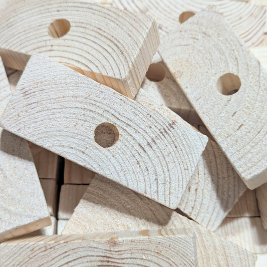 Close-up of wooden blocks with holes for making bird toys.