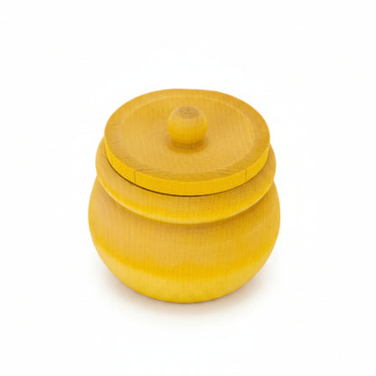 A small round wooden lidded container or jar in a bright yellow finish, photographed on a clean white background.